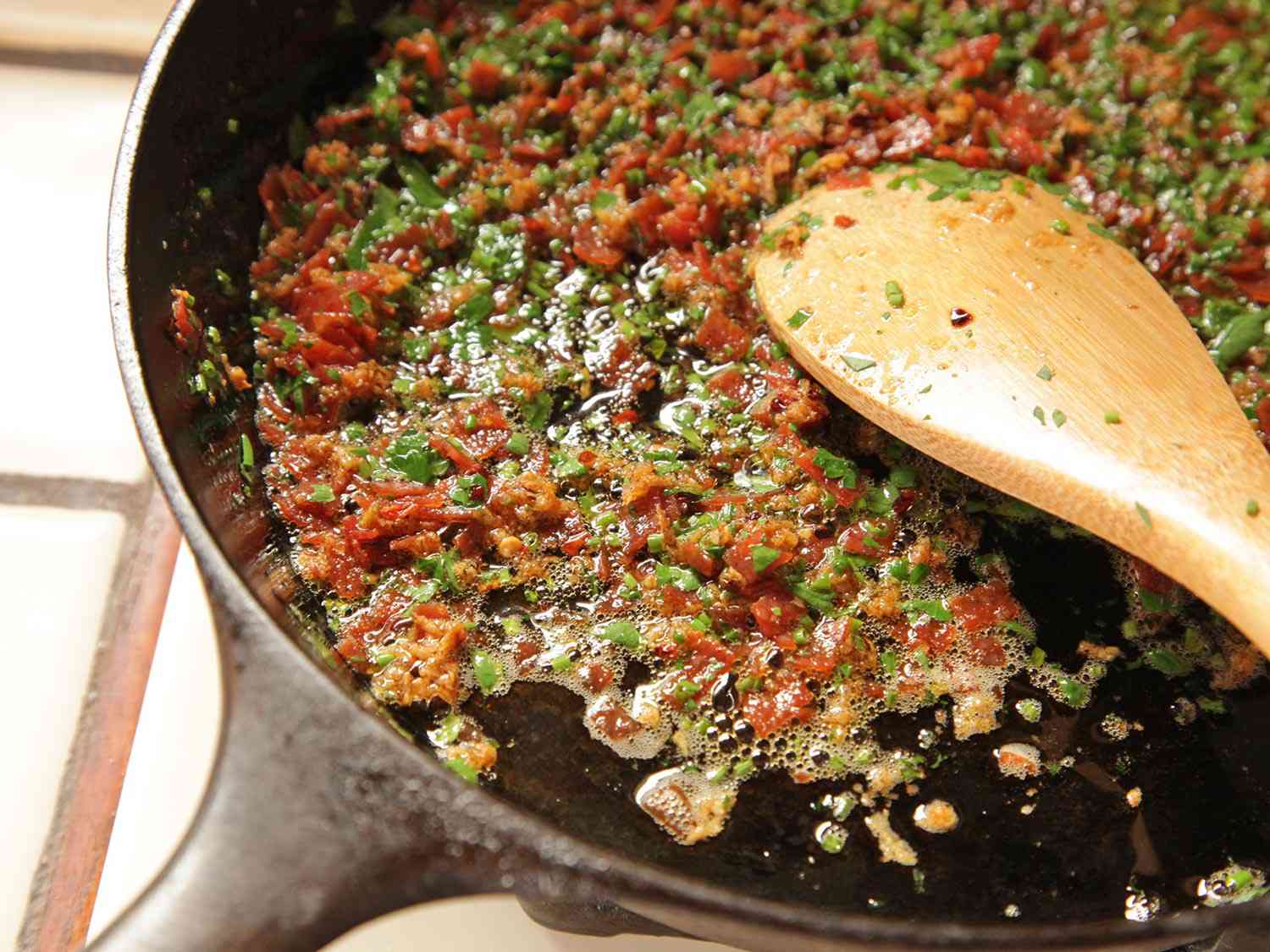 Sauteing finely-diced pepperoni and parsley for pepperoni garlic knots