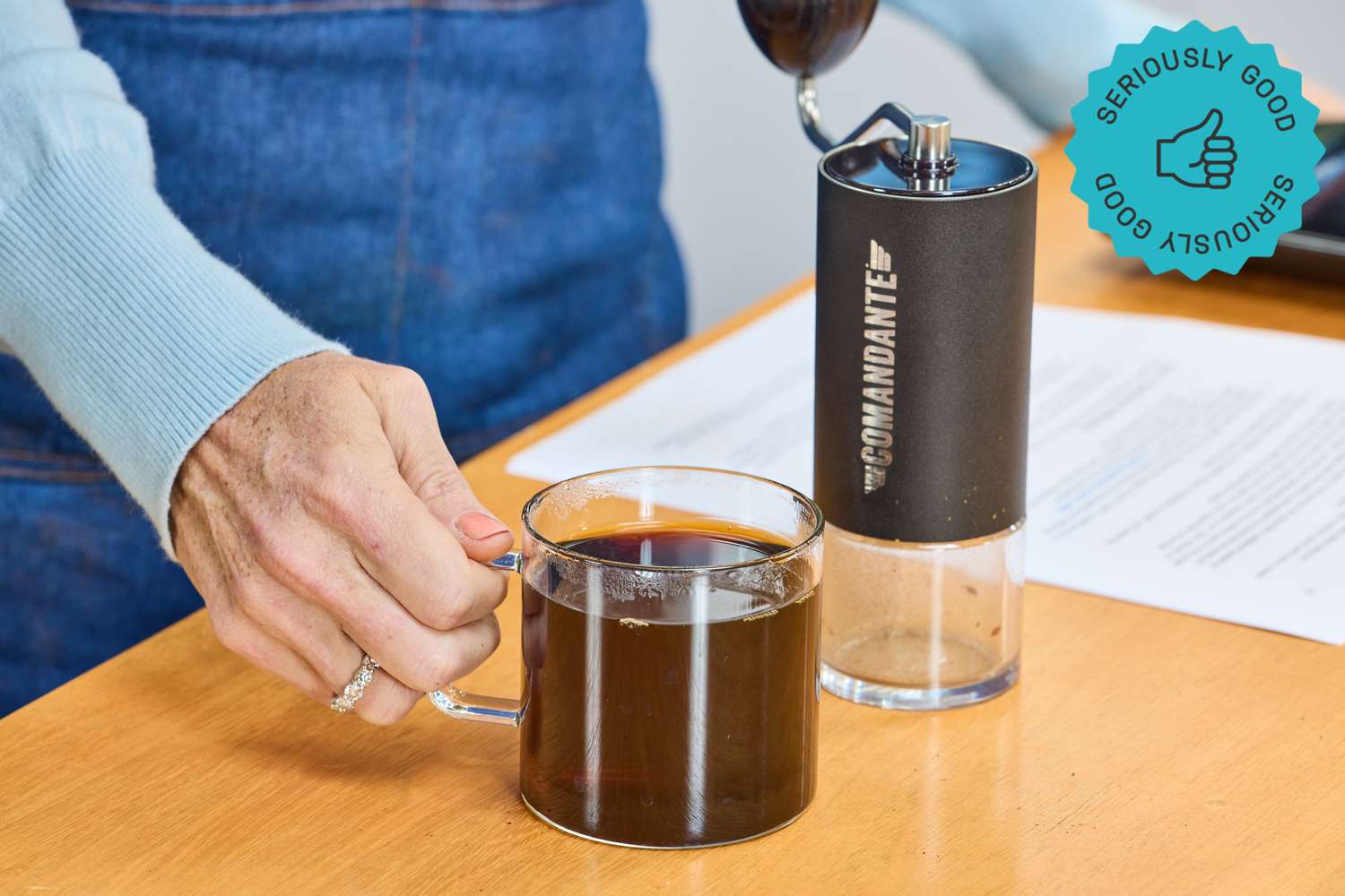 the comandante hand grinder with a cup of coffee next to it