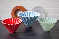 Three different sized Origami drippers sitting on a wooden surface