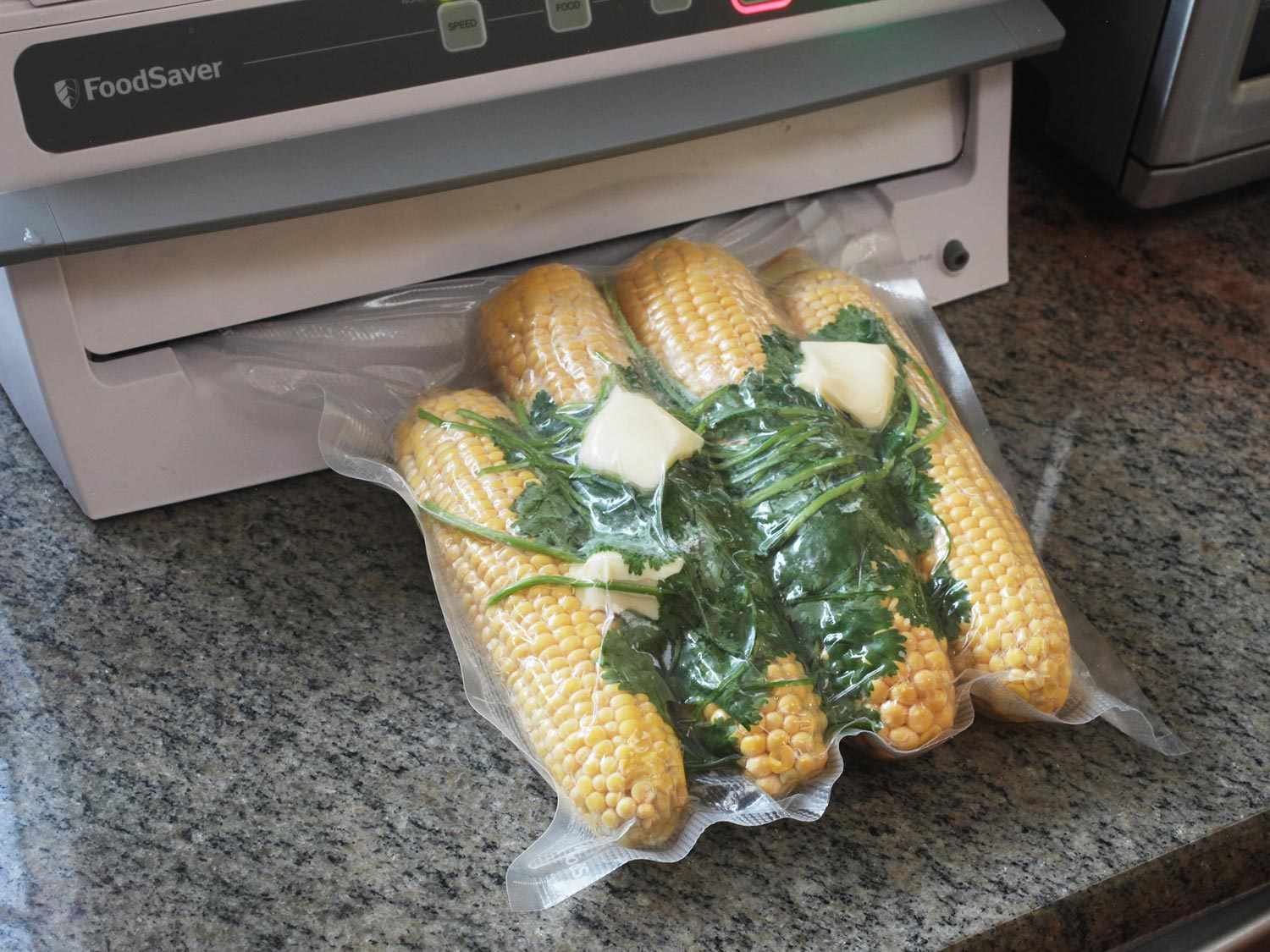 Shucked corn cobs vacuumed-sealed with aromatics and butter.