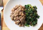 Overhead view of black-eyed peas with ham hock, served with a side of braised greens.