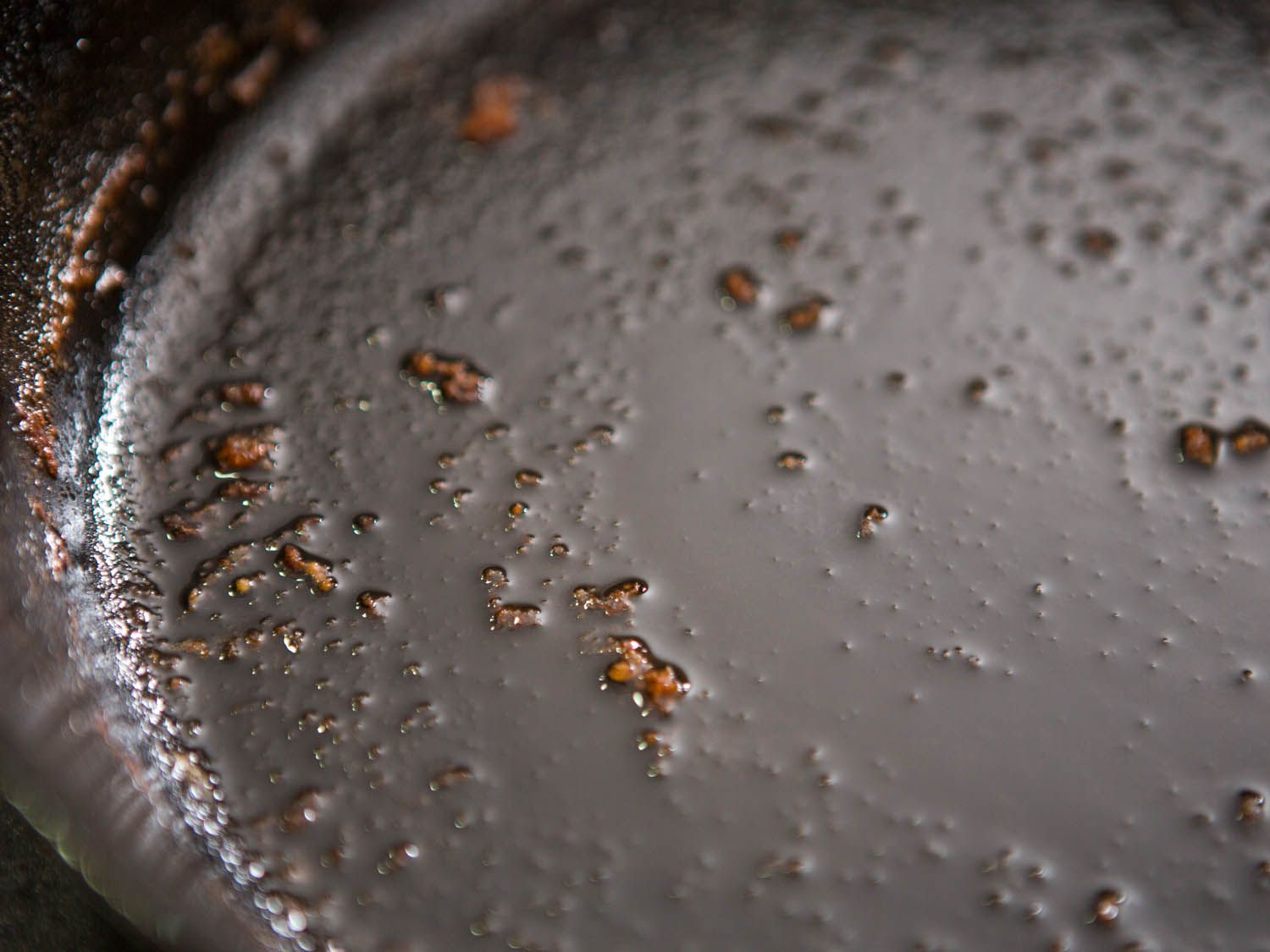 The remains of fried chicken in the bottom of a pan, ready to be made into gravy.