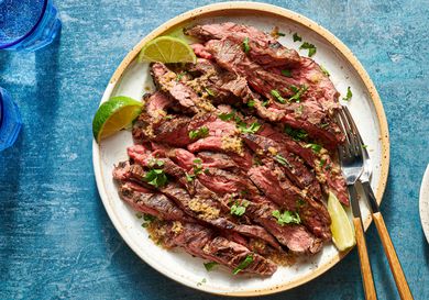 Grilled skirt steak with mojo marinade served on a plate with lime wedges