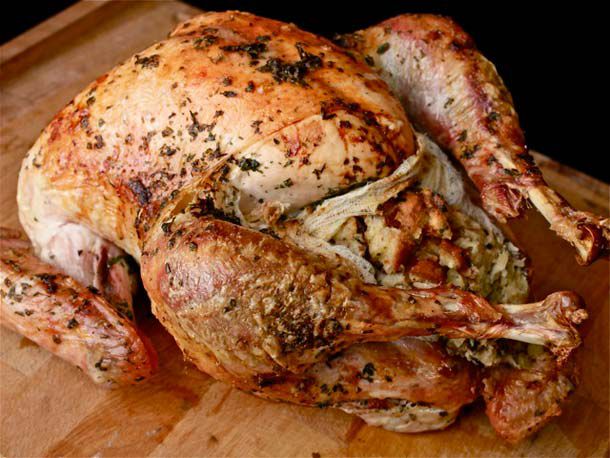Closeup of whole roast turkey with exposed stuffing in cheesecloth pouch