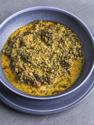 Egusi soup served in a blue ceramic bowl.