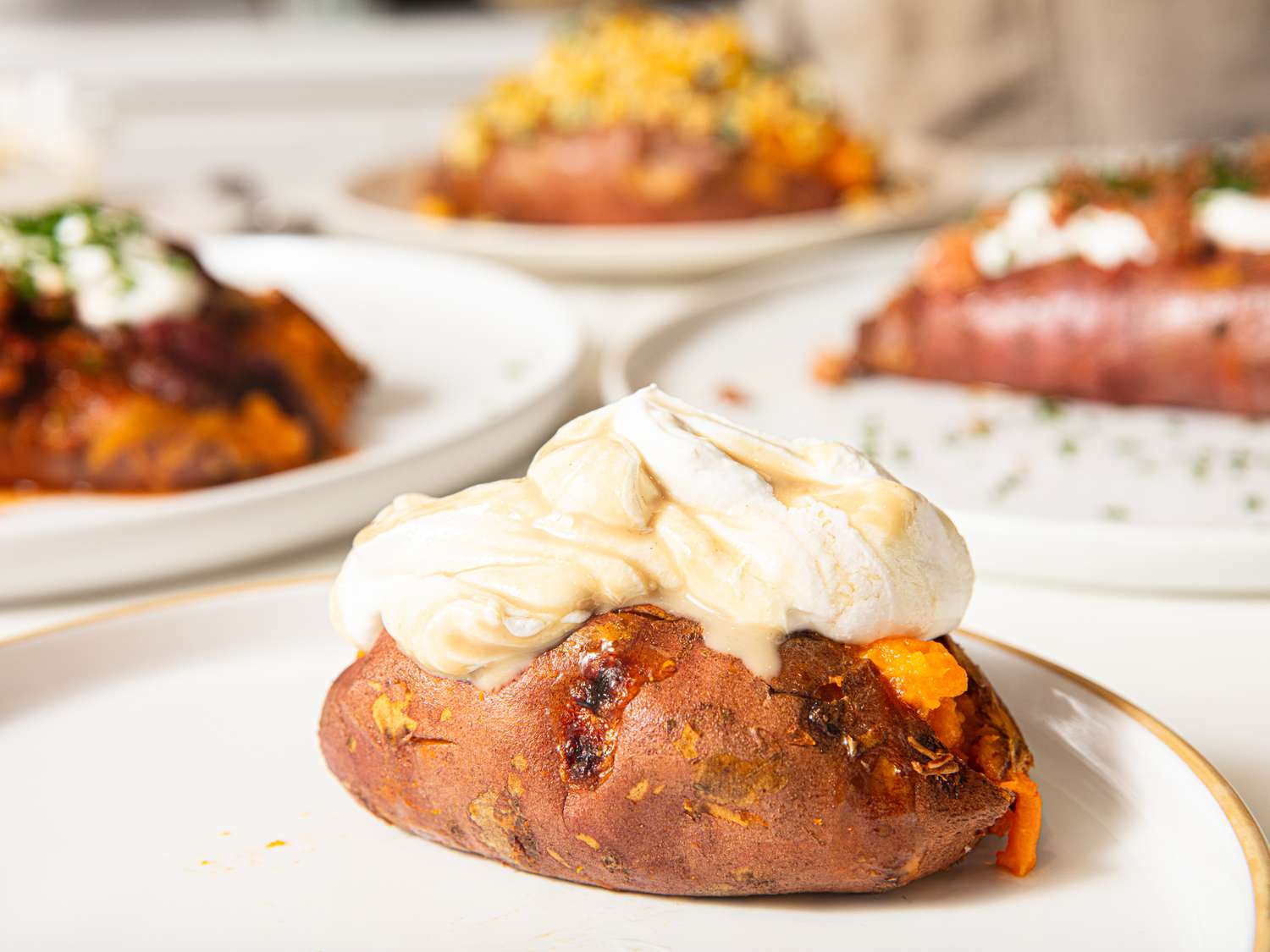 Side view of loaded backed sweet potato topped with ricotta
