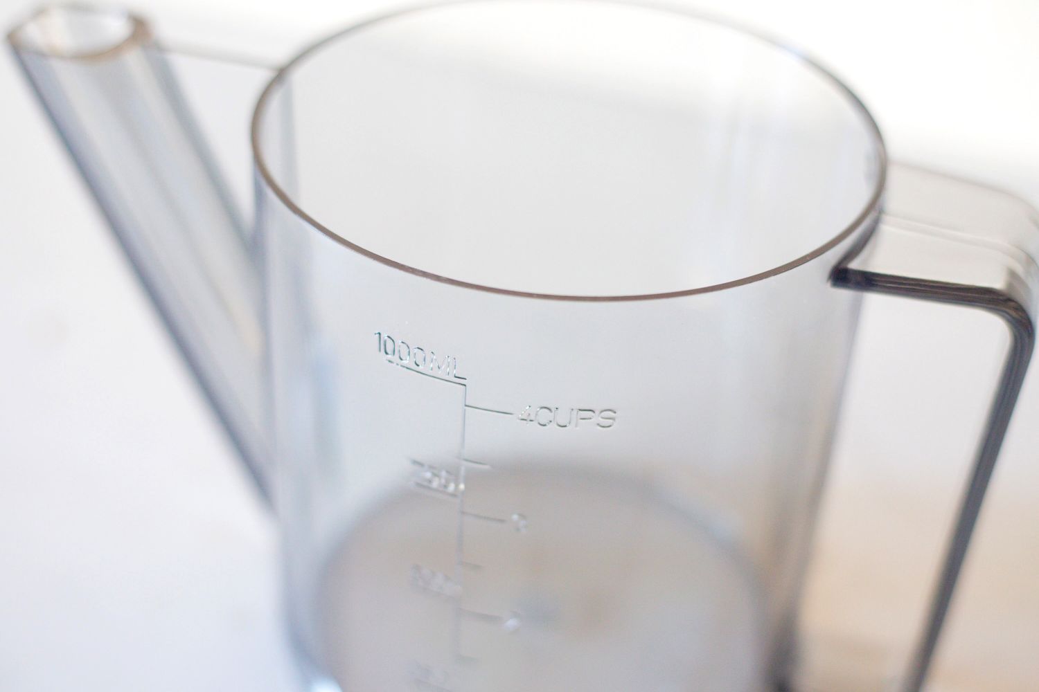 A measuring jug with volume markings shown up to 4 cups or 1000 milliliters