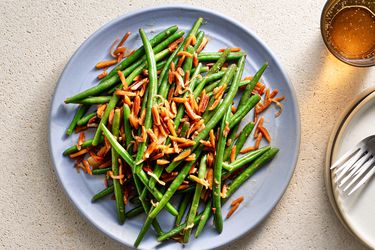 The composed green beans on a blue ceramic plate.