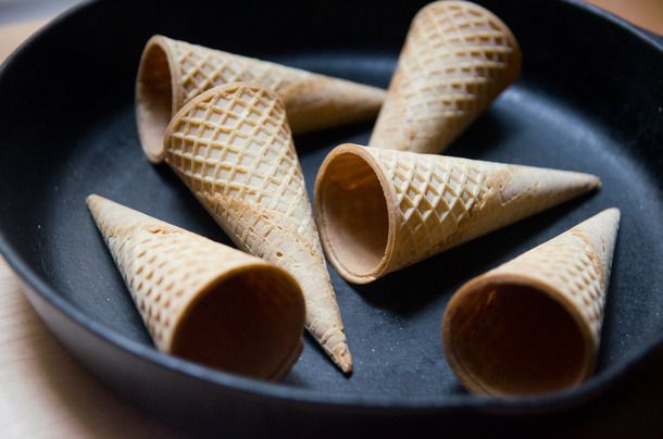 Half a dozen ice cream cones, arranged in a cast iron skillet.