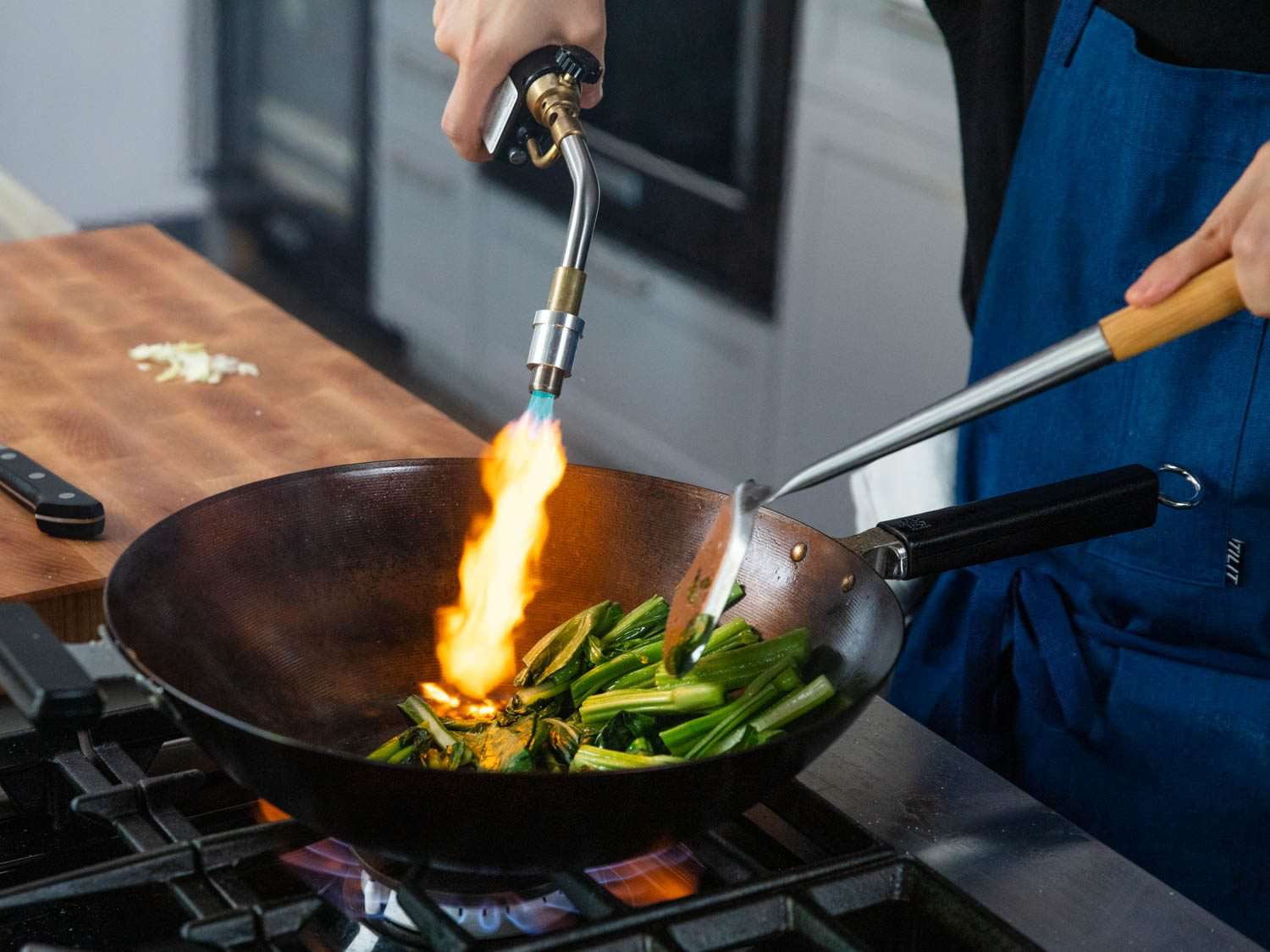 Blowtorching vegetables in a wok