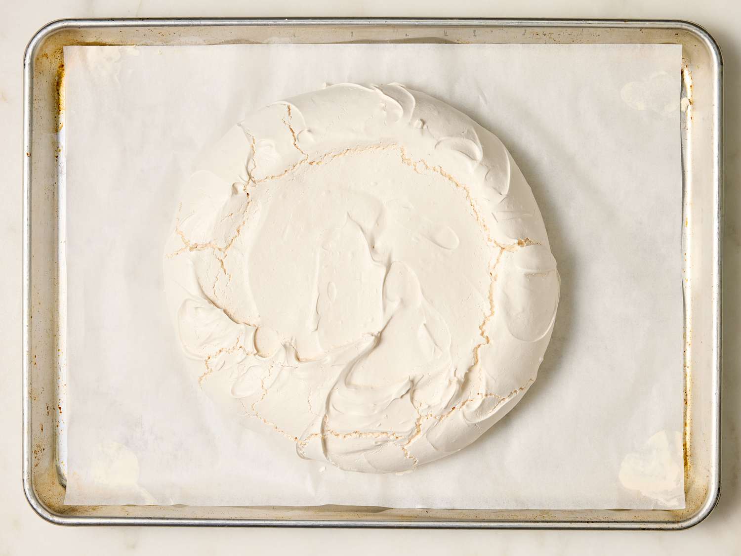 Pavlova meringue base baked on a parchment-lined baking sheet