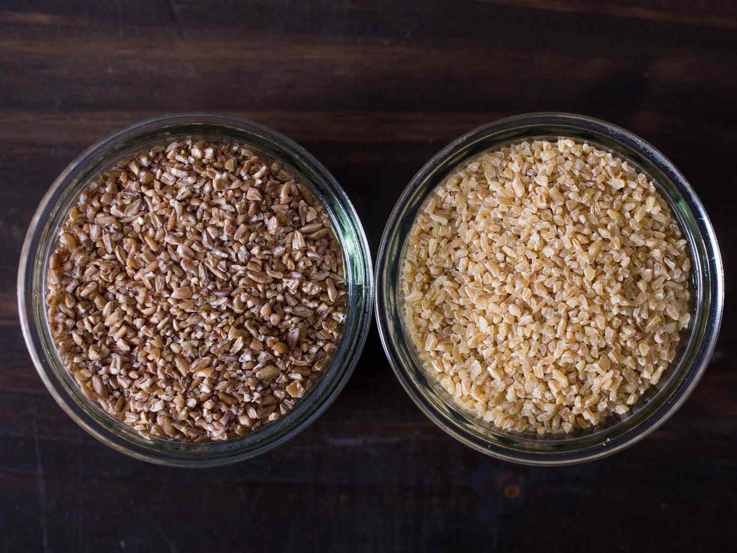 Overhead of two glass bowls of bulgur wheat for tabbouleh.