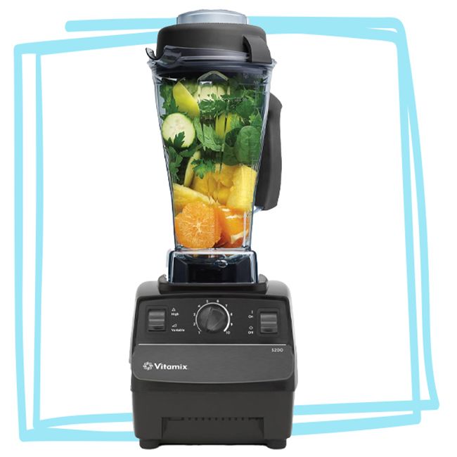 Vitamix blender with various fruits and vegetables inside its container