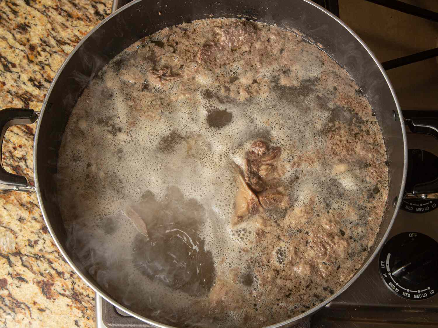 Overhead view of foamy impurities in boiling water 