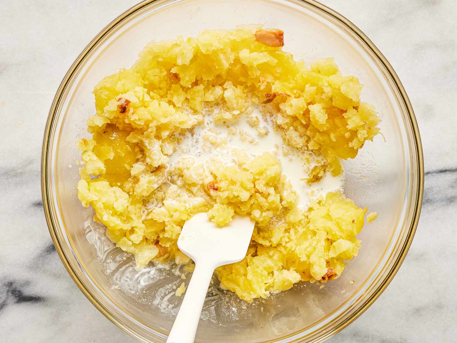 Overhead of adding cream to mashed potatoes