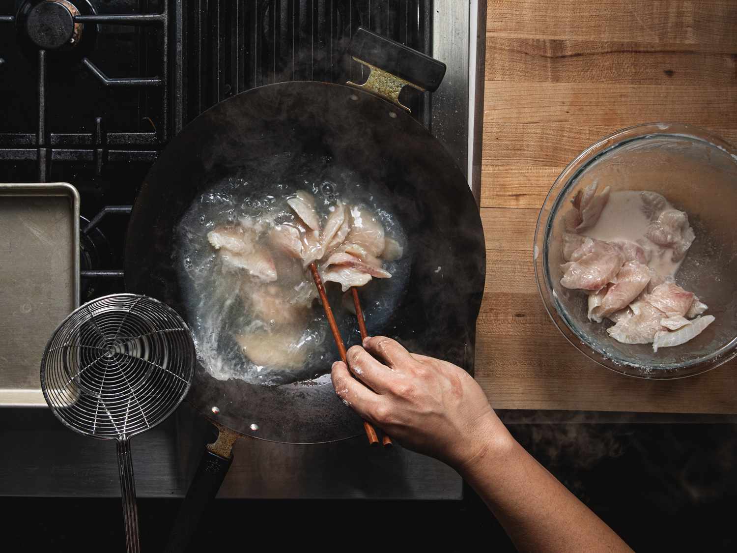 Overhead view of passing-through chicken in a wok