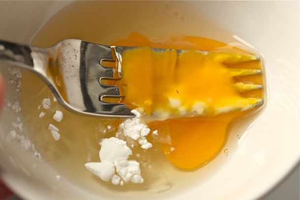 Using a fork to whisk egg and cornstarch together.