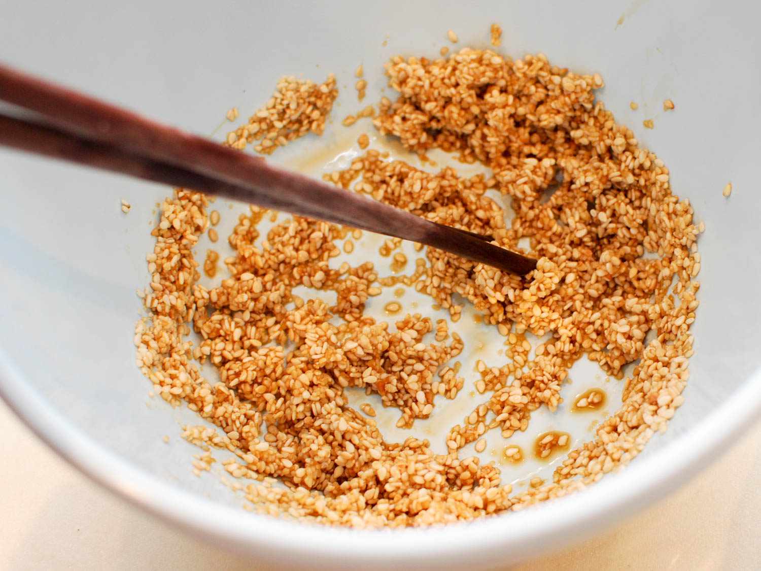 Stirring sesame seeds into soy sauce and mirin. 