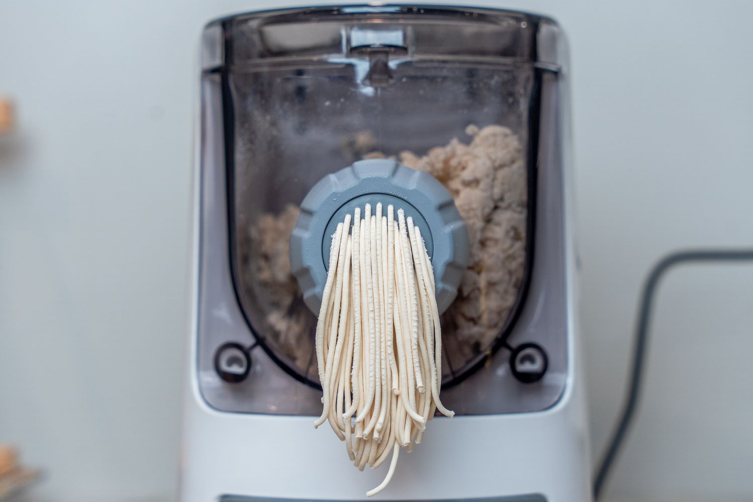 A pasta extruder making spaghetti