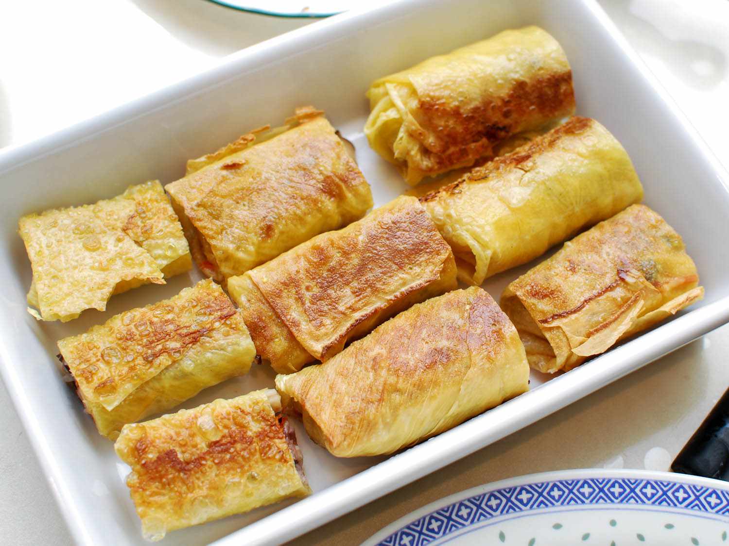 Halved bean curd rolls arranged in a baking dish.