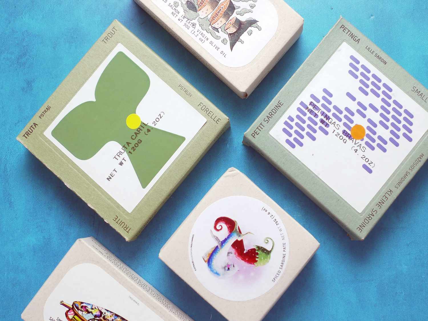 five jose gourmet and ABC tins on a blue backdrop