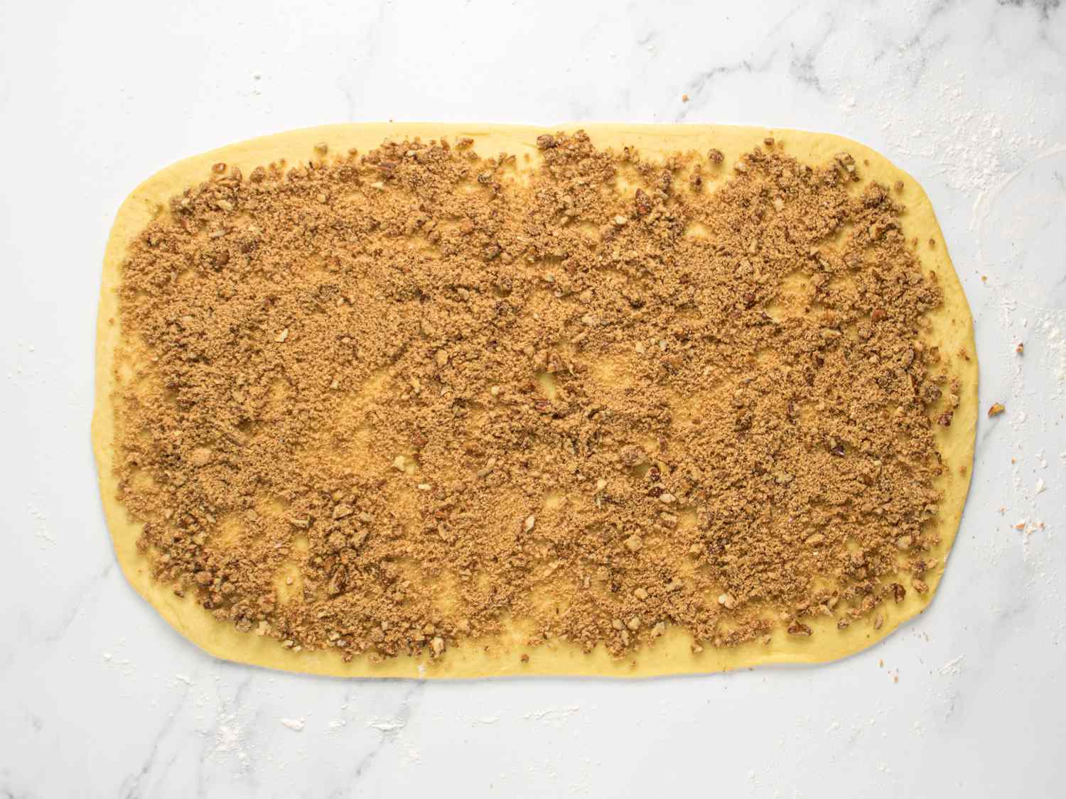scattering pecan filling on the entire surface of the dough