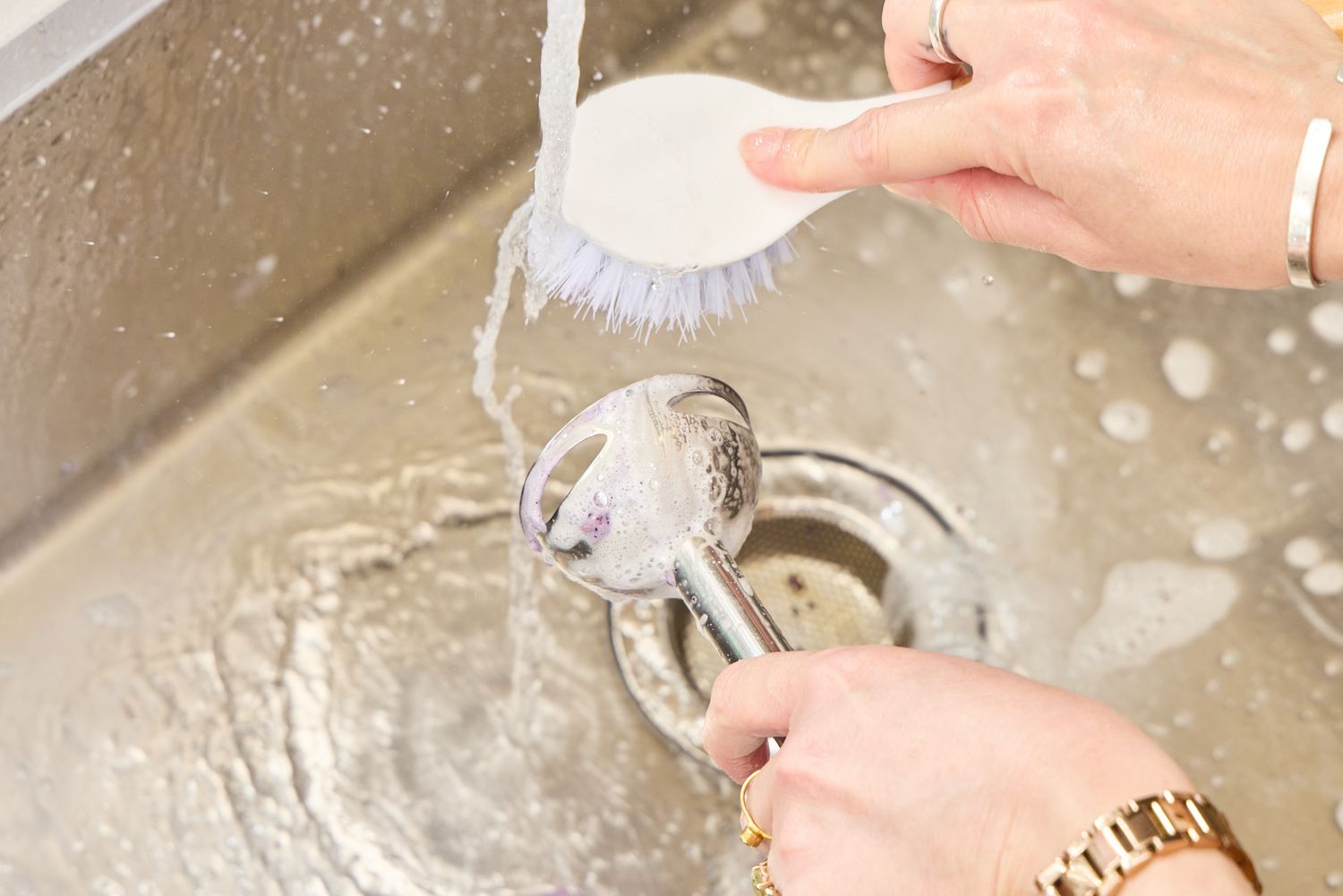 A person washes the Hamilton Beach 2-Speed Hand Blender