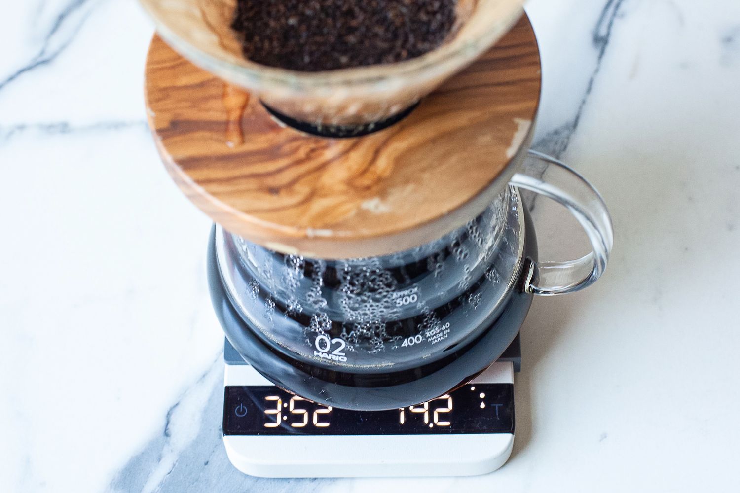 A pour-over coffee brewing setup on a Acaia Lunar Scale showing weight and timer readings