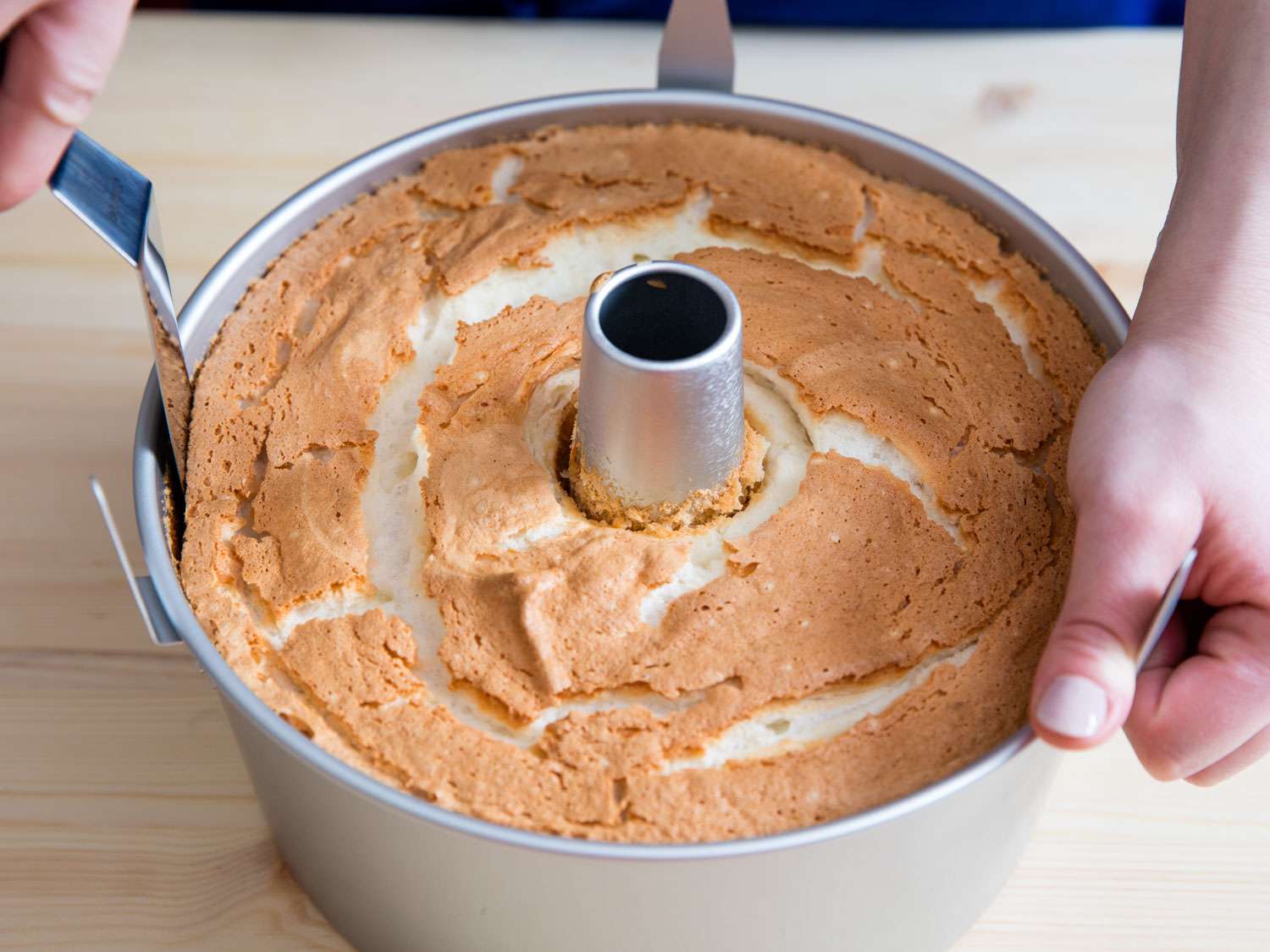 Using an offset spatula to loosen a baked angel food cake from an angel food cake pan