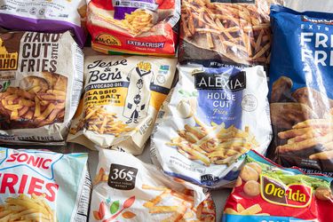 A variety of frozen French fry brands arranged on a surface showcasing their packaging designs