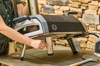 A person checks the legs on the Ooni Karu 2 Multi-Fuel Pizza Oven