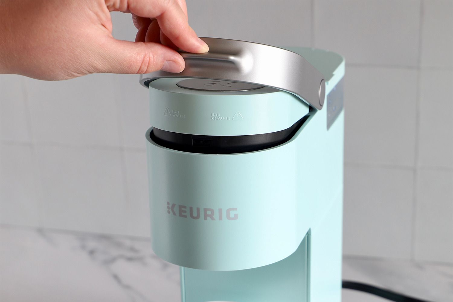 Keurig coffee machines k mini single on counter being used by person 