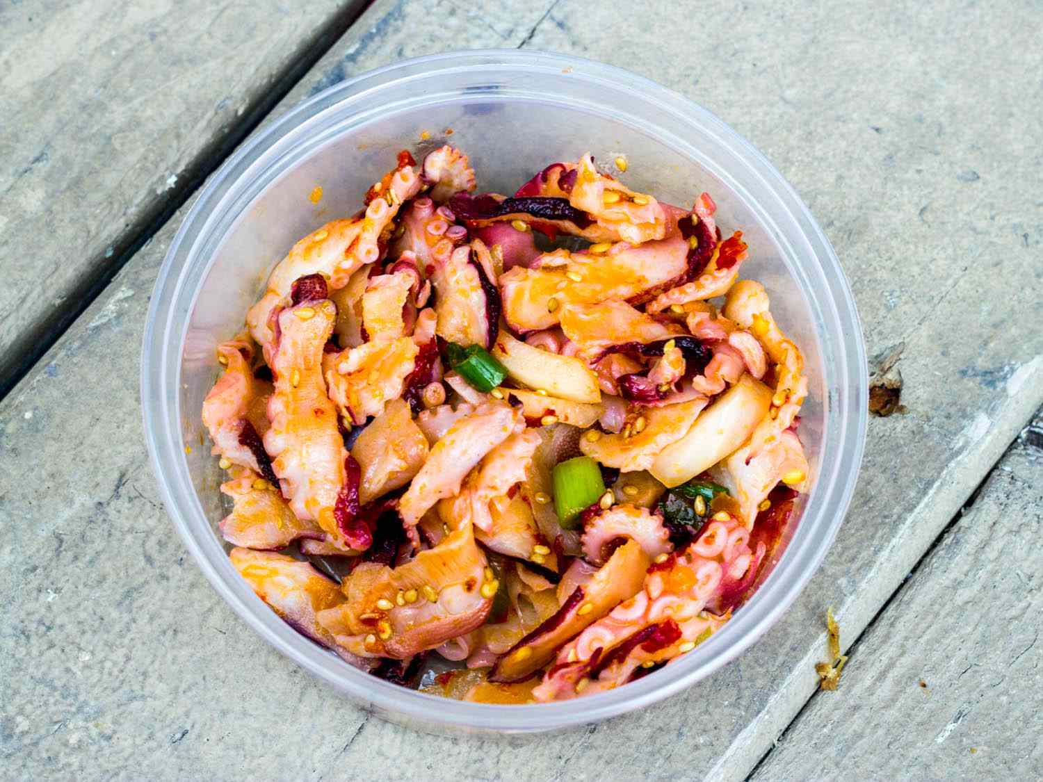A takeout container of octopus poke. 
