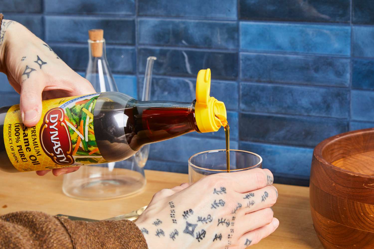 Pouring sesame oil into a glass on a kitchen counter