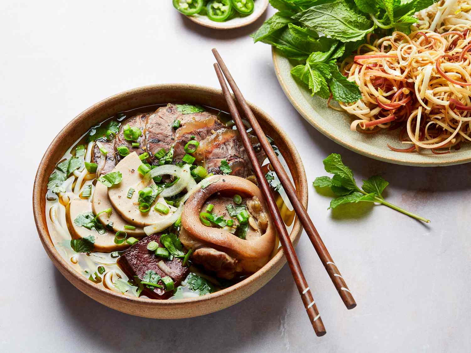 Side view of bun bo hue with accompaniments 