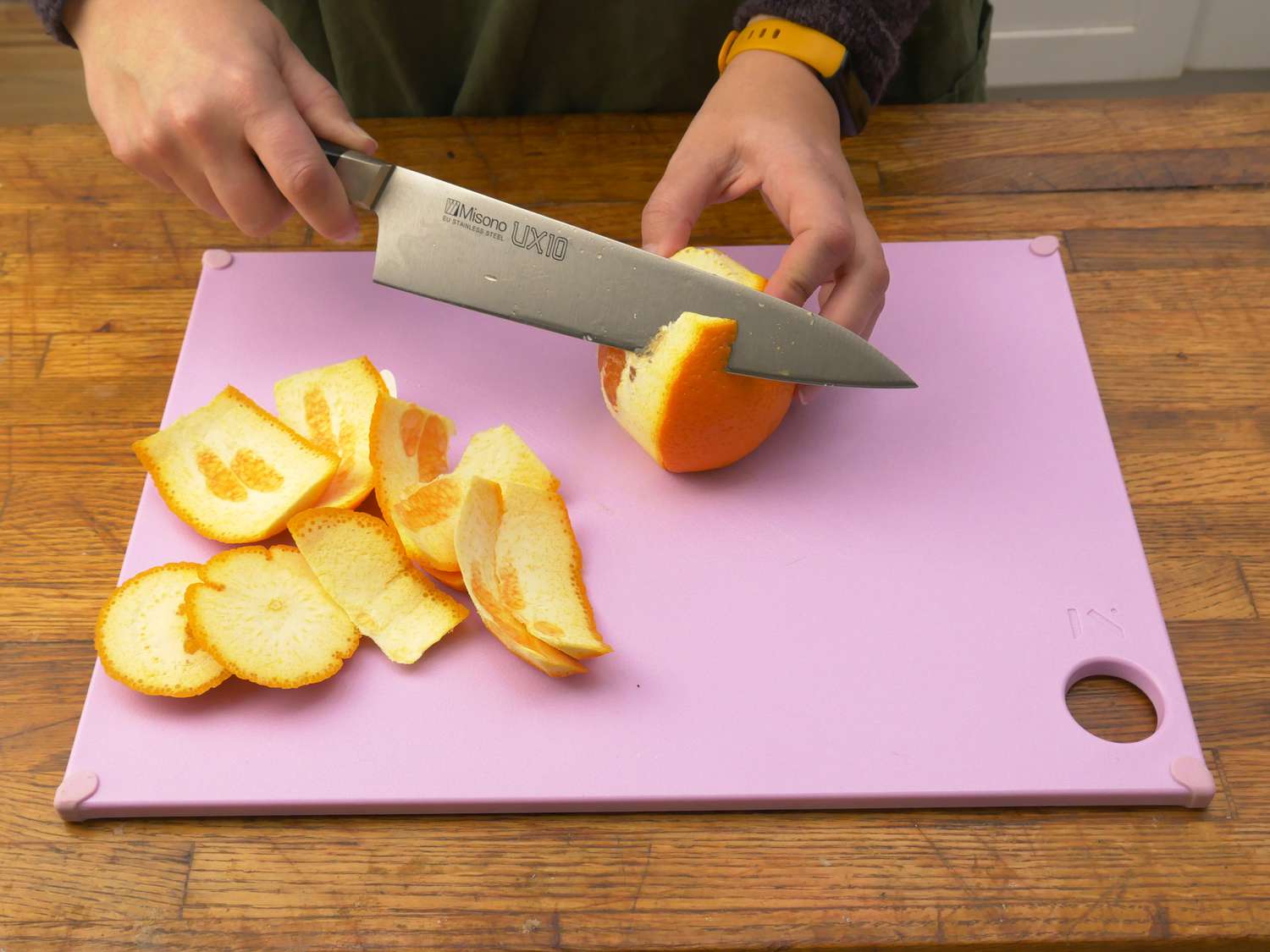 a person peeling an orange on the reboard