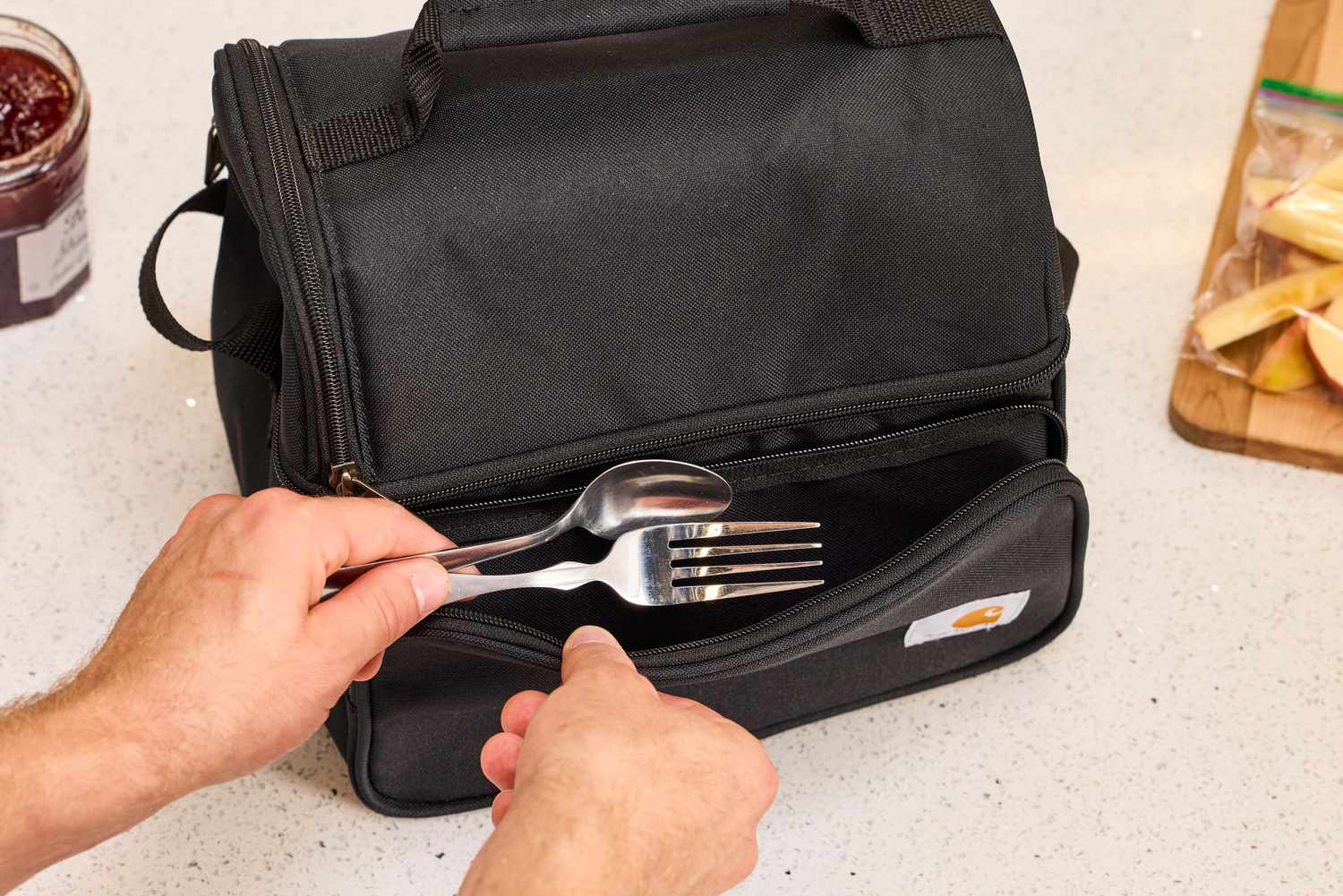 Cutlery being packed into the front compartment of a lunch box