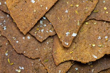 Shingled pieces of sourdough rye crackers sprinkled with flaky salt, coriander, and fennel seeds