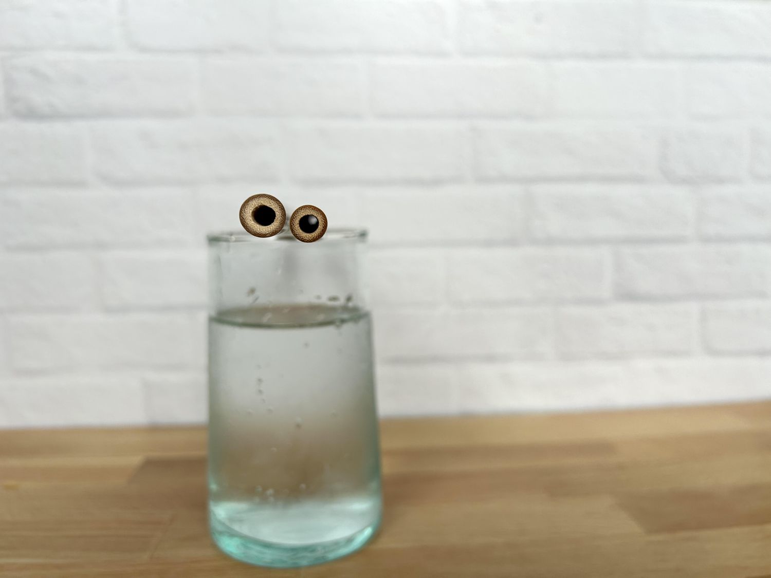Two bamboo straws on a glass of water