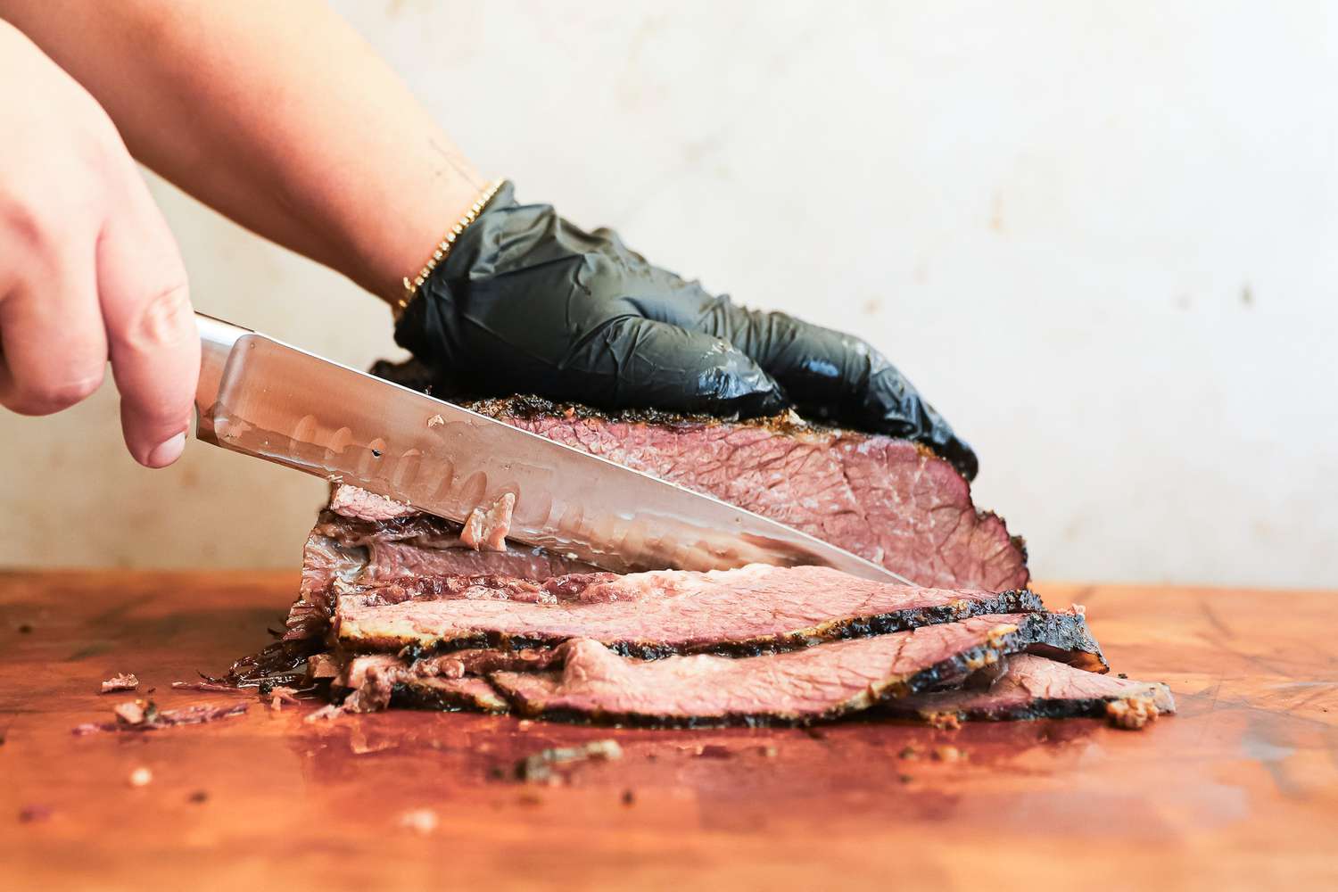A person slicing meat using the Wusthof Classic Carving Knife