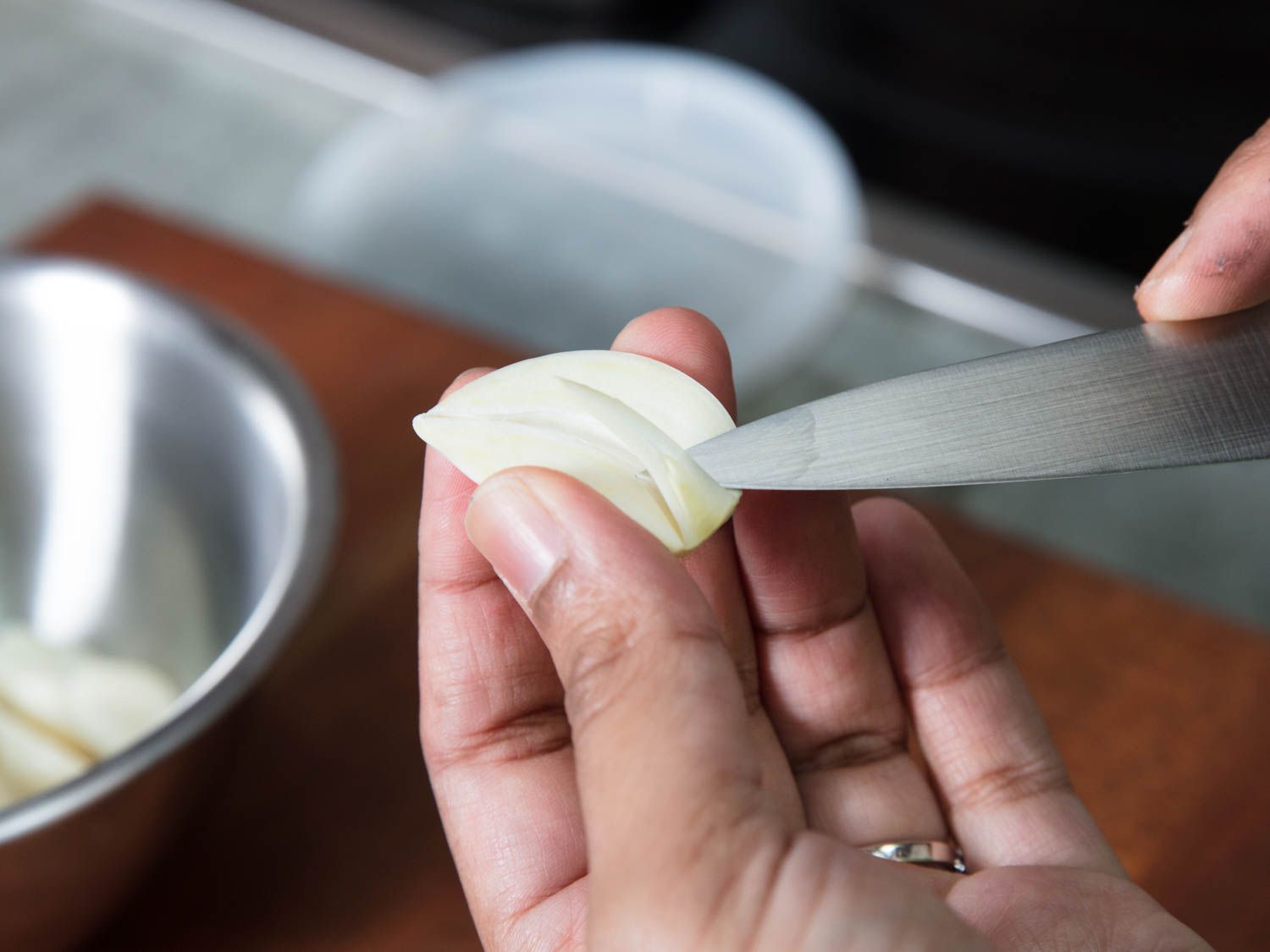 Using a knife to de-germ garlic.