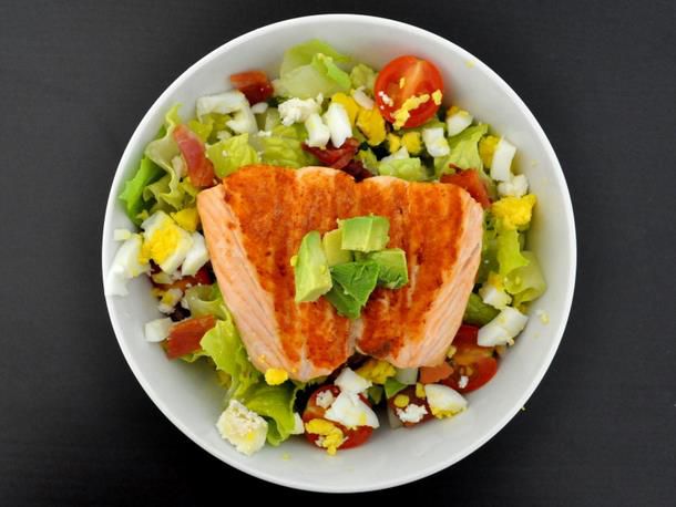 A California Cobb salad with salmon, goat cheese, and hard-boiled eggs in a bowl