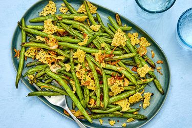 A plate of air-fried green beans with shattered frico and shallots