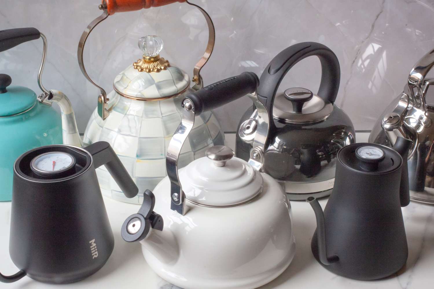 A collection of different styles of teapots displayed on a surface