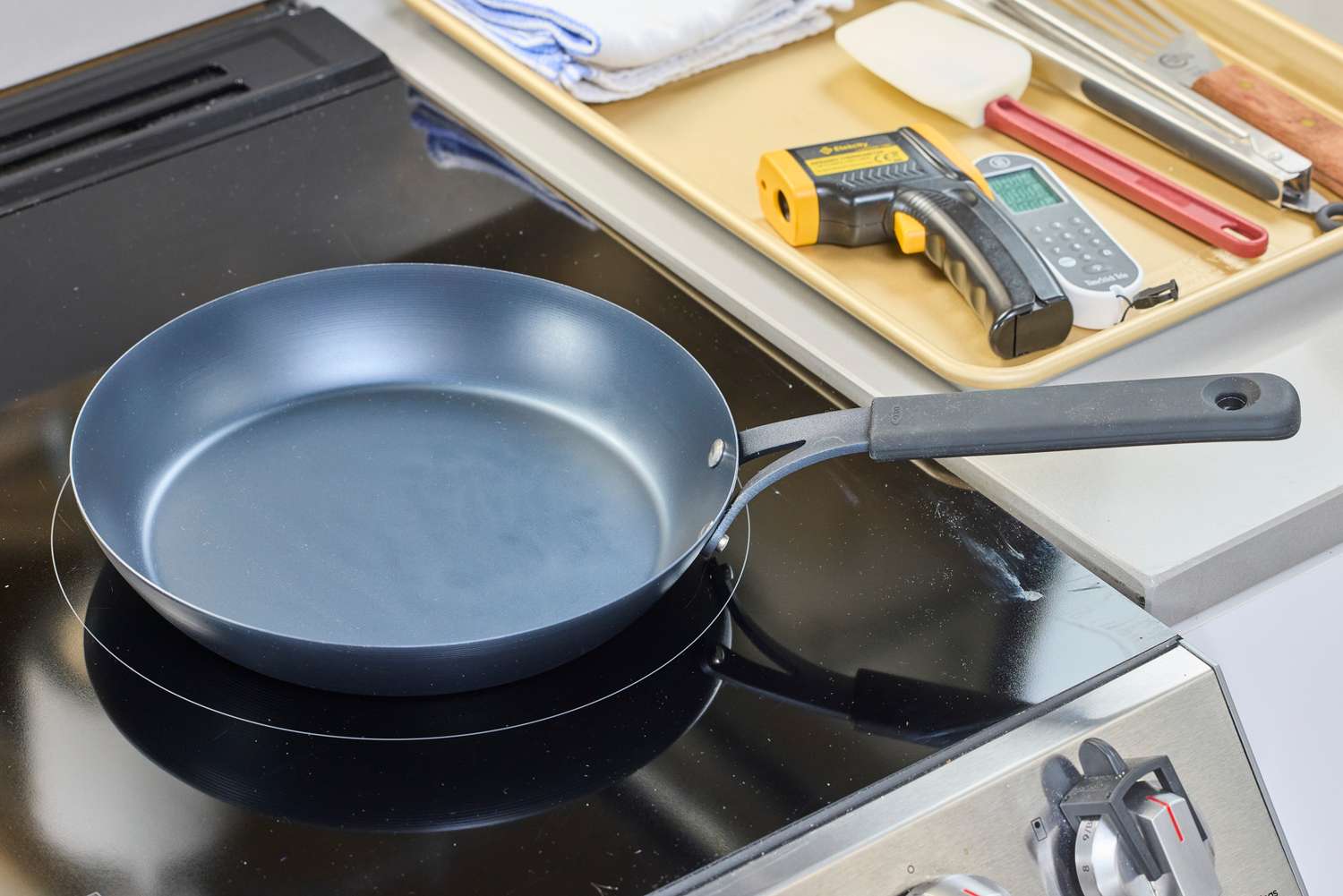 The OXO Obsidian 10 Inch Pre-Seasoned Carbon Steel Frying Pan on a stovetop