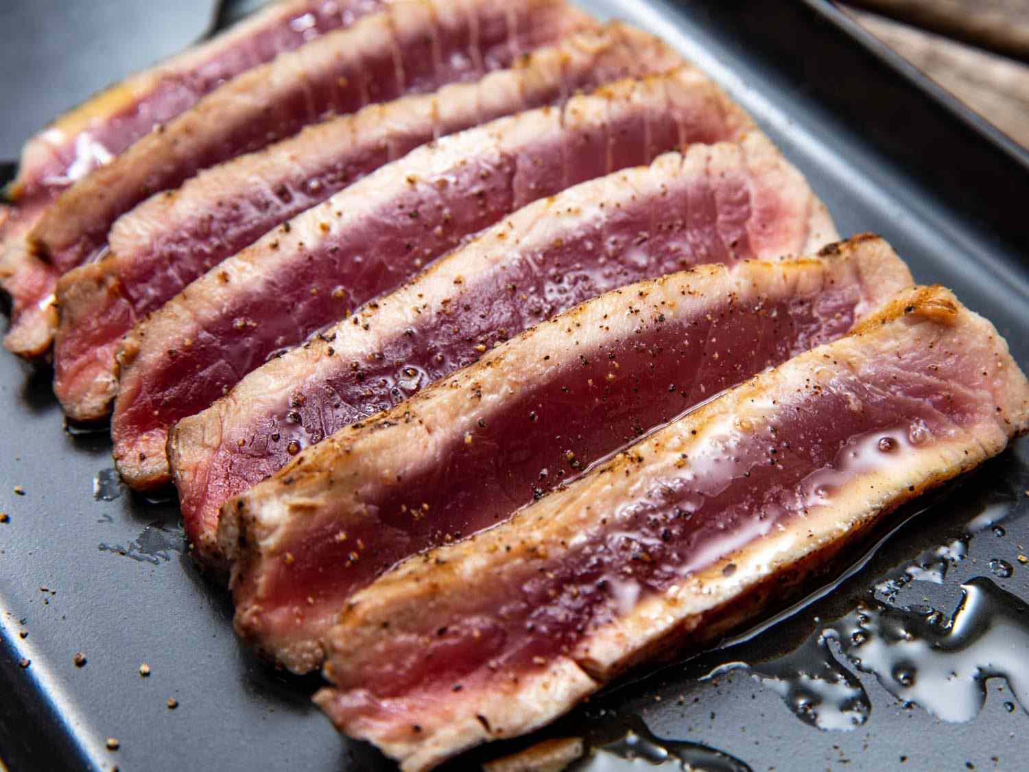 Slices of grilled tuna, cooked just around the edges and totally rare (raw, even) in the center, drizzled with olive oil and seasoned with salt and freshly ground black pepper