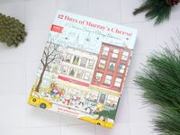 12 days of murrays cheese box on a white tile surface with greenery