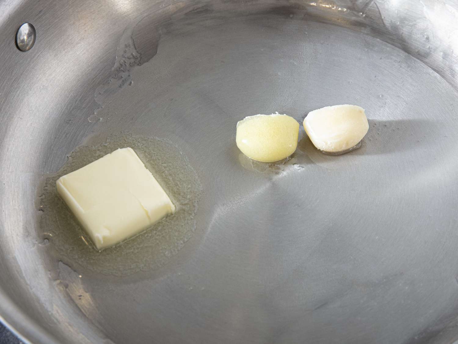 Overhead view of garlic, ginger, and butter in saucepan