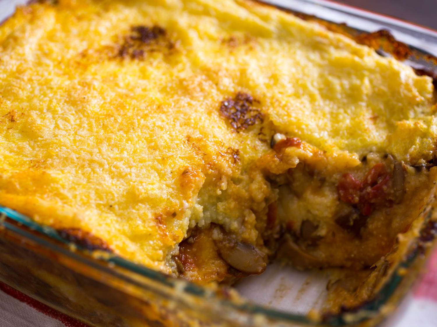 The baked polenta lasagna. A messy "piece" has been excavated from the baking dish.