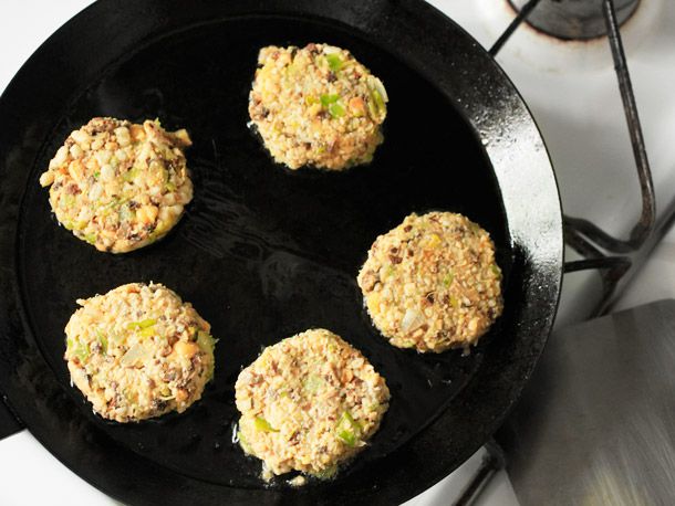 Uncooked veggie patties inside of an oiled carbon steel pan.